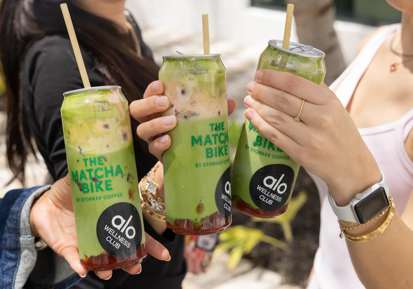 Guests holding Strawberry Dream matchas at an Alo Wellness Club event
